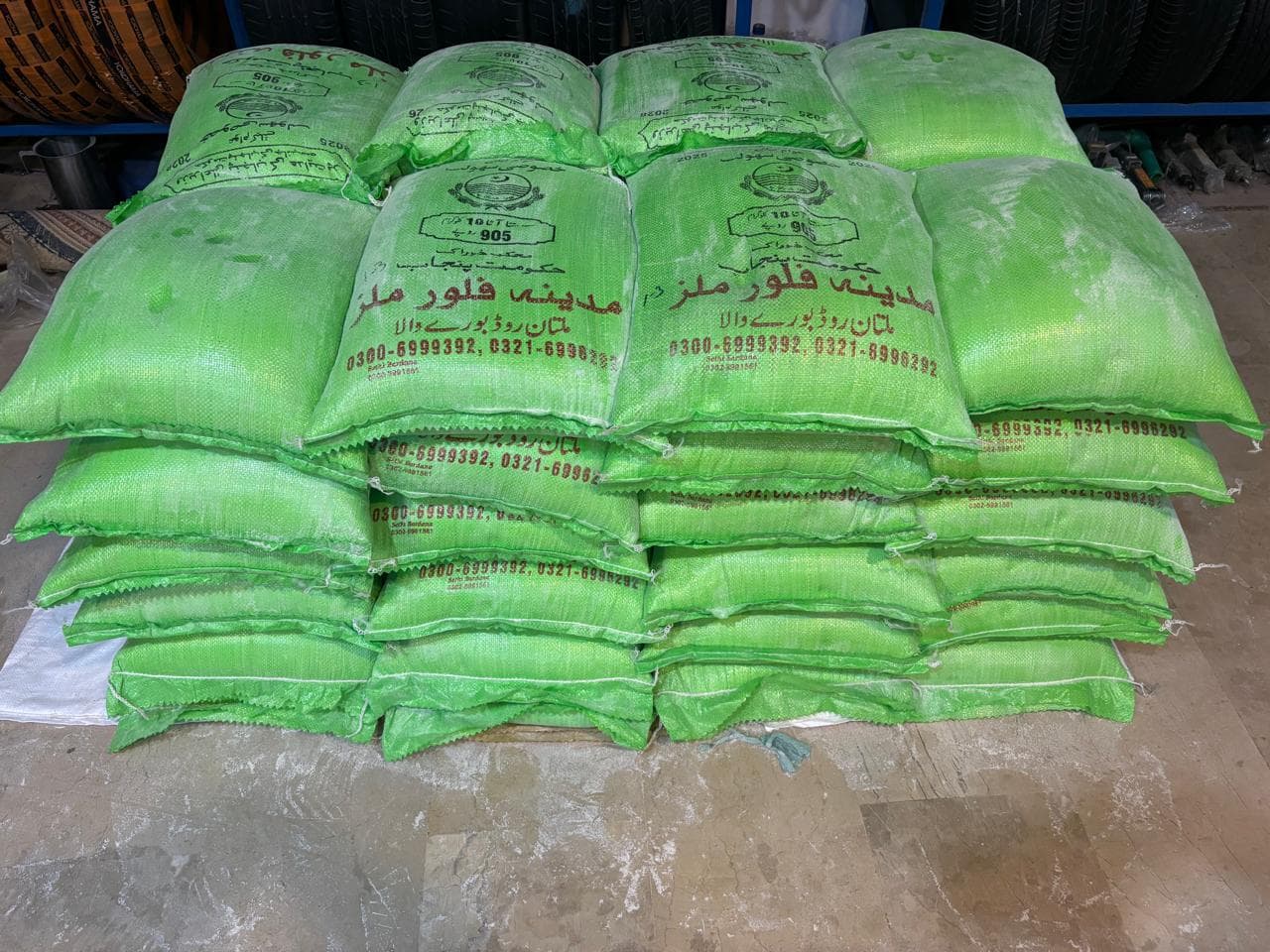 Large stack of green flour bags prepared for distribution