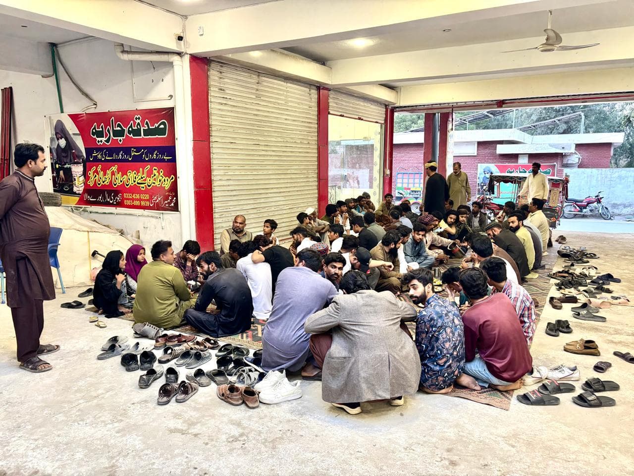 Community iftaar program with people seated for a meal in Burewala